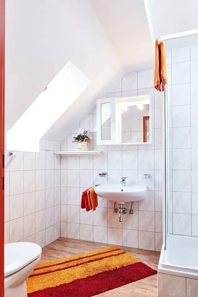 Badezimmer der Ferienwohnung Drei mit Waschbecken, Dachfenster und Dusche