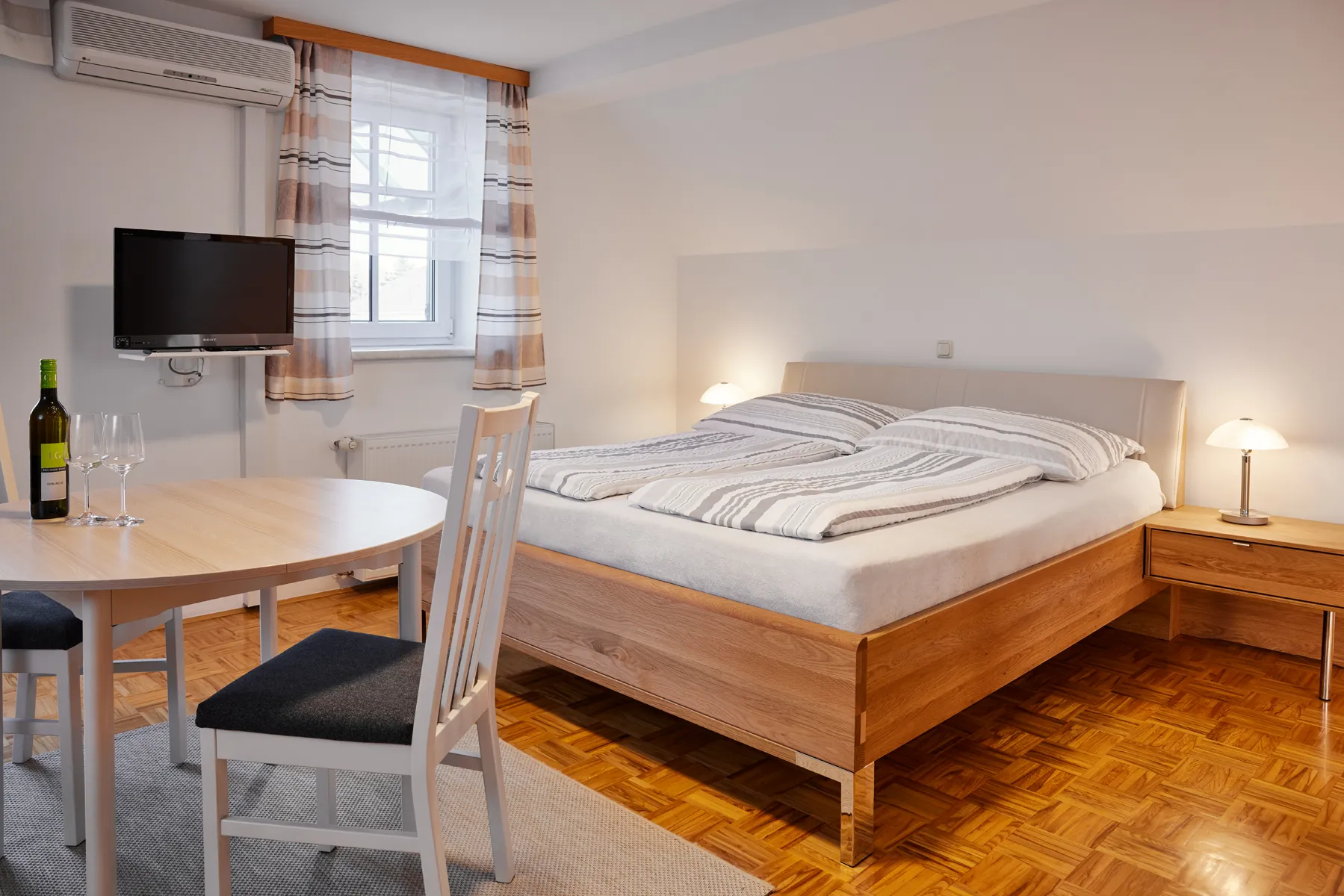 Schlafbereich der Ferienwohnung Vier mit Doppelbett und Esstisch